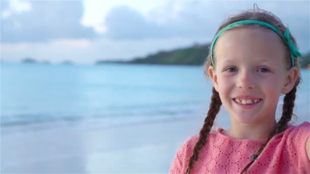 Adorable niñita haciendo selfie en la playa tropical blanca. MOCIÓN LENTA
 - Imágenes, Vídeo