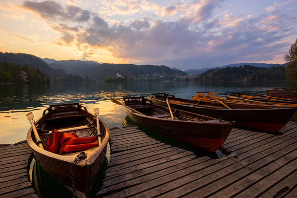 Barcos de madera tradicionales Pletna en el backgorund de la iglesia en la isla en el lago Bled, Eslovenia. Europa
. - Foto, imagen