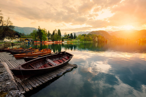 Tradycyjne drewniane łodzie nadmiar na backgorund Kościół na wyspie jeziora Bled, Słowenia. Europy. - Zdjęcie, obraz