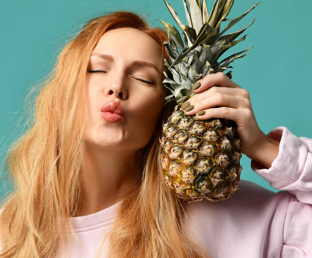 Young happy beautiful sexy woman posing laughing with pineapple fruit - Foto, Bild