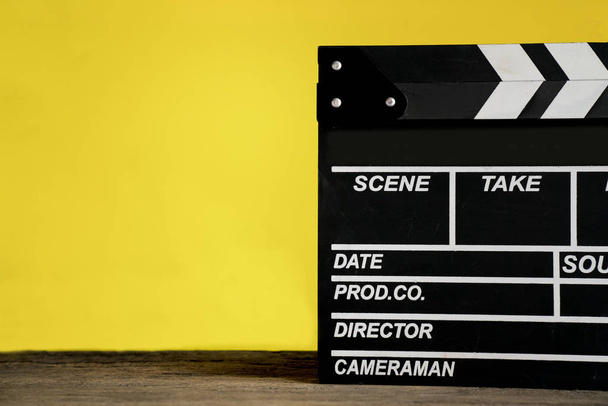movie clapper on wood table with yellow background ; film, cinem - Foto, Bild