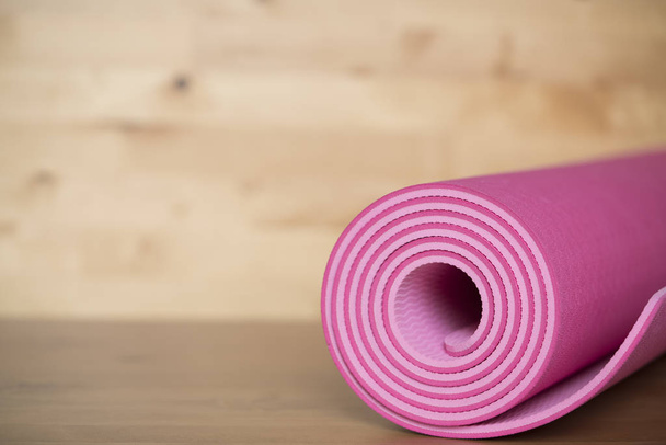close up of pink yoga mat on the table, sport and healthy concep - Фото, изображение