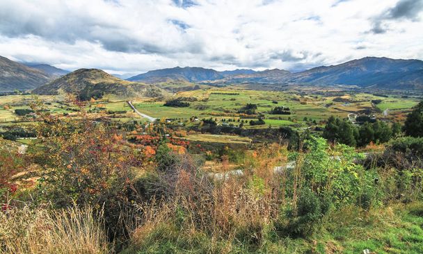 Дивлячись на краєвид сільськогосподарських угідь і гори з точки зору поблизу Ванака на Південному острові Нової Зеландії - Фото, зображення