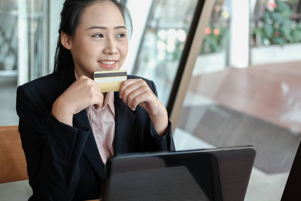 Kobieta trzyma karty kredytowej i za pomocą komputera do sukienki online - Zdjęcie, obraz