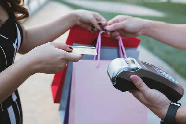 женщина производит оплату кредитной картой через терминал. cust
 - Фото, изображение