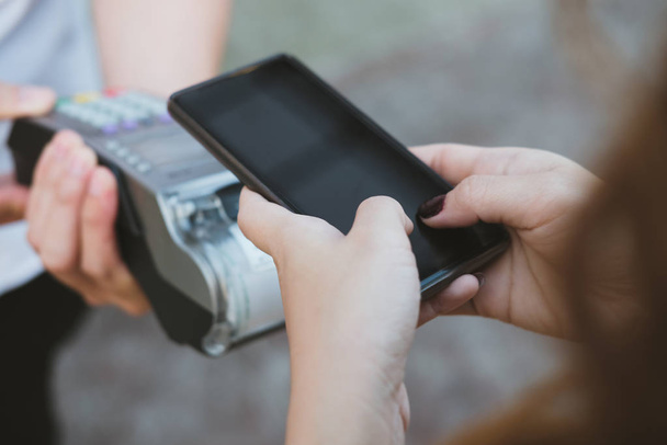 γυναίκα χρησιμοποιούν smartphone για να κάνουν την κινητή πληρωμή με ηλεκτρονική ανάγνωση - Φωτογραφία, εικόνα