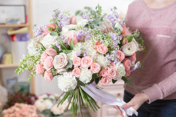 όμορφο πολυτελές μπουκέτο μικτή λουλούδια στο χέρι γυναίκα. το έργο του το ανθοπωλείο σε ένα ανθοπωλείο. - Φωτογραφία, εικόνα