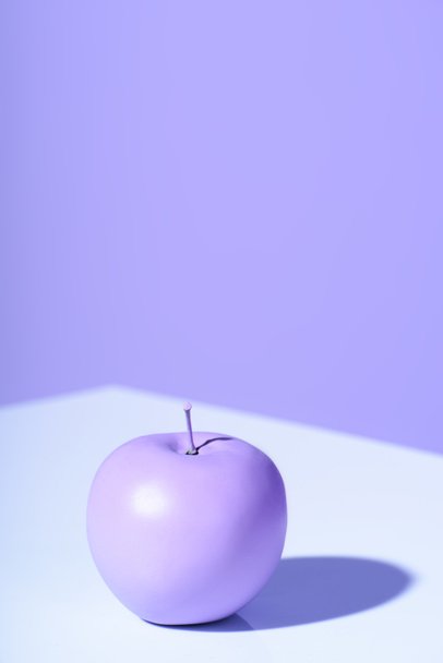 purple apple on violet background with copy space - Photo, Image