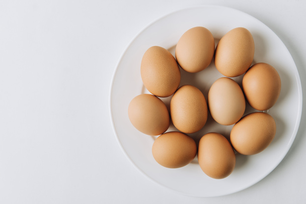 brown eggs laying on white plate on white background  - Photo, Image