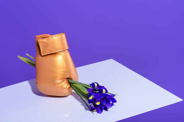 purple iris flowers in golden boxing glove - Fotó, kép