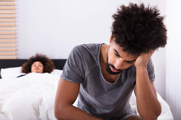 Depressed Man Sitting On Bed In Front Of Woman - Photo, Image