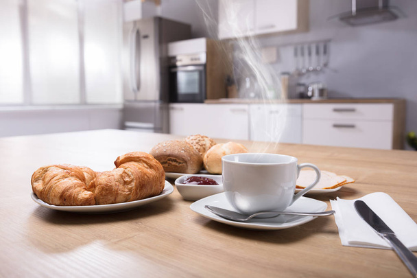 Close-up Of Croissants And Cup Of Hot Coffee On Wooden Desk - Zdjęcie, obraz