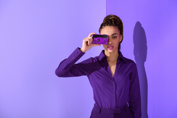 elegante hermosa mulata chica en chaqueta púrpura tomar fotos en la cámara
 - Foto, Imagen