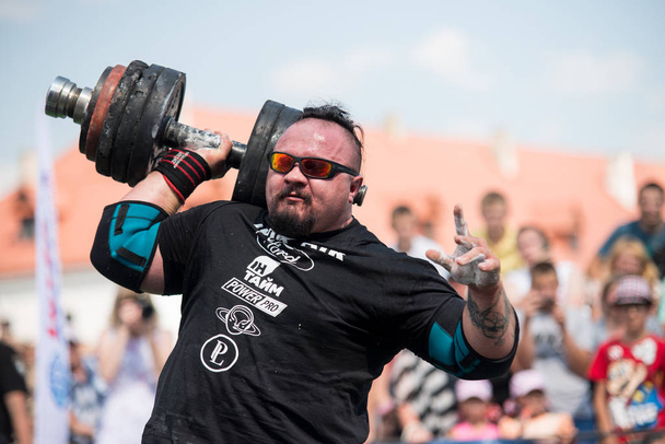 Strongman raises heavy dumbbell with one hand at competitions, Ukraine, 2017 - Foto, Imagen