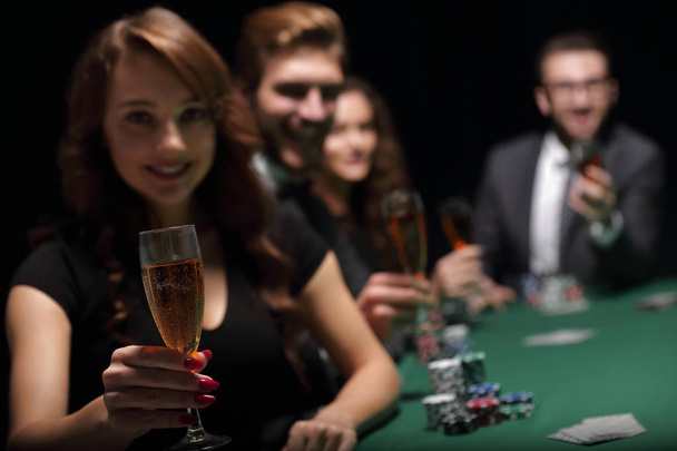 fashion woman with glasses of wine,sitting at a table in a casino - Foto, Bild