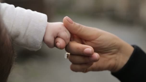 Madre sosteniendo la pequeña mano del bebé con ternura y cuidado, sentimientos maternos
 - Metraje, vídeo
