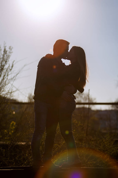 Hombre y mujer besándose en el telón de fondo del sol poniente. Silueta. Foto:
. - Foto, Imagen
