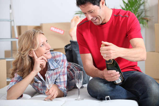 Couple drinking champagne in new home - Photo, image