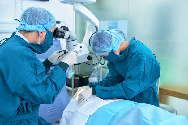 Équipe de travailleurs médicaux effectuant une chirurgie oculaire
 - Photo, image