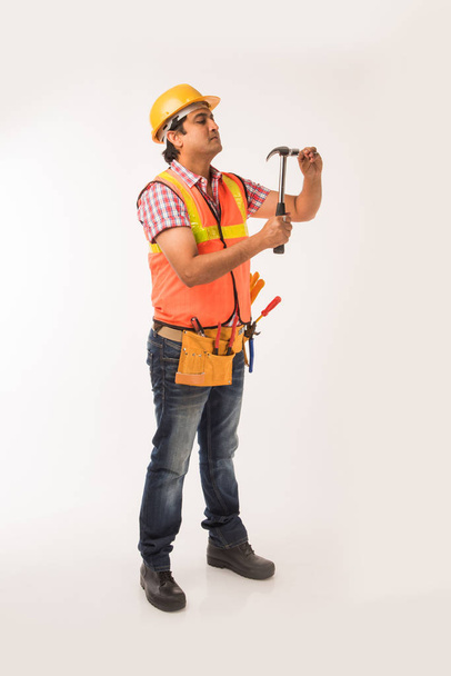 Indian handsome electrician engineer in action, standing isolated over white background - Foto, Imagem