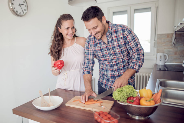 young couple cooking together in kitchen - Photo, Image