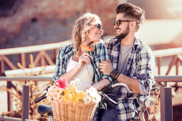 glückliches junges Paar spaziert mit dem Fahrrad durch die Stadt - Foto, Bild