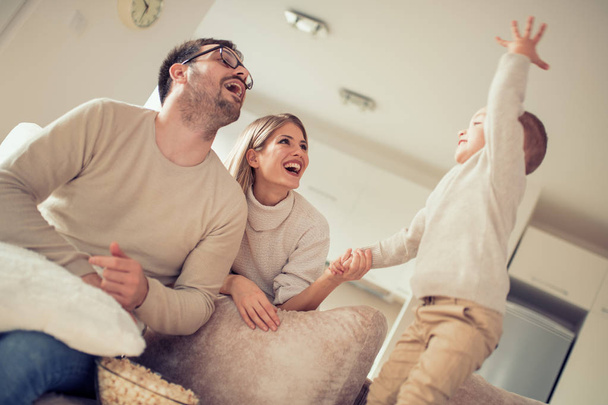 Szczęśliwa rodzina młodych, oglądanie telewizji i o wielki czas w domu - Zdjęcie, obraz