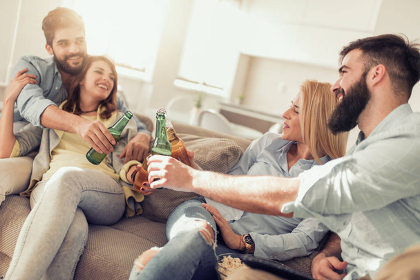 Веселая компания друзей, пьющих пиво на диване
 - Фото, изображение