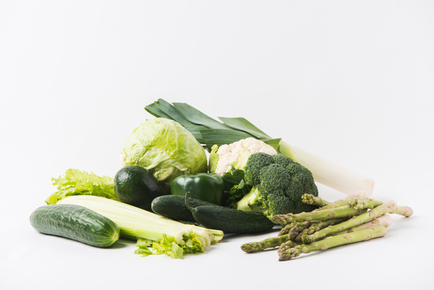 різні зелені овочі, що лежать на білому тлі
 - Фото, зображення