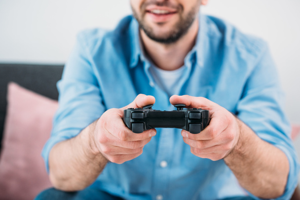 visão parcial do homem jogando videogame em casa
 - Foto, Imagem