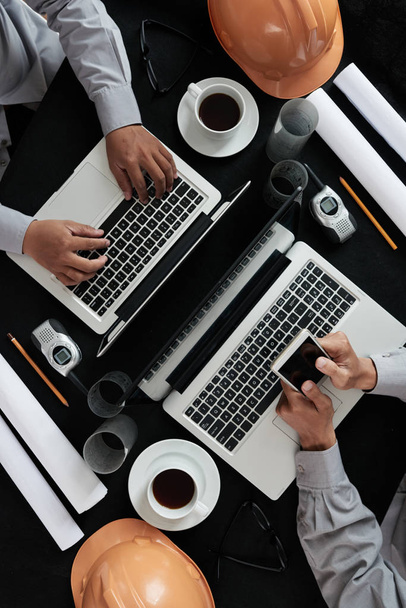 Bouw zakenmensen werken op laptops, bekijken van bovenaf - Foto, afbeelding