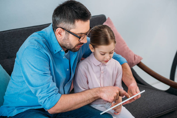 father and daughter using tablet together at home - Photo, Image