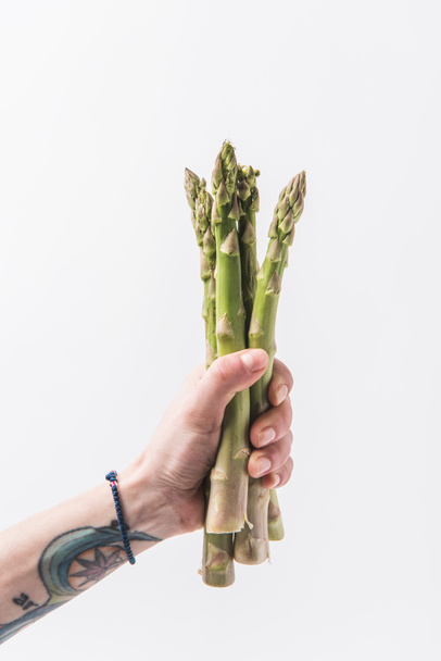 Hand holding green asparagus stalks isolated on white background - Photo, Image