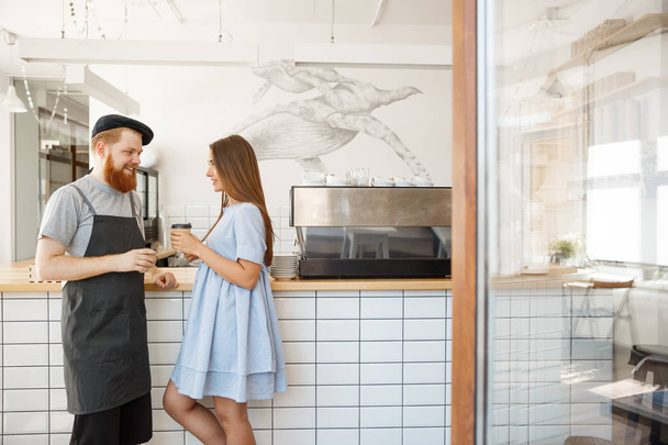 Кофе Бизнес Концепция - молодой умный бородатый бармен наслаждаться разговорами и отдавать чашку кофе для красивых клиентов
. - Фото, изображение