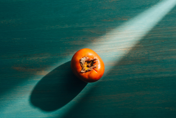 top view of persimmon on table with light and shadow - Foto, Bild