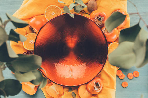 вид зверху великої червоної тарілки на помаранчевій скатертині
 - Фото, зображення
