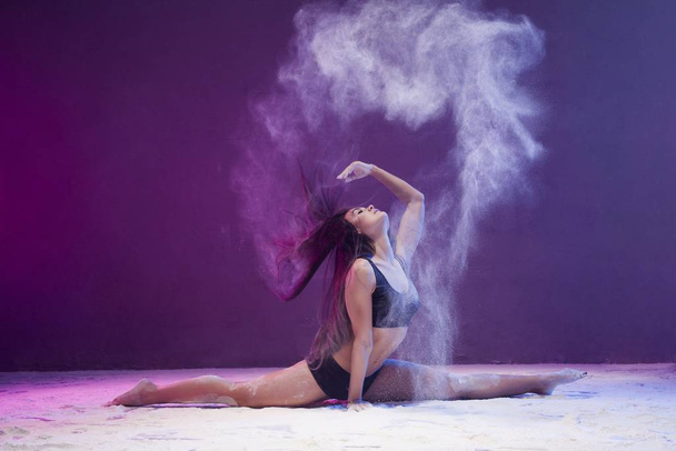 Woman in a split shot in white dust cloud - Foto, imagen
