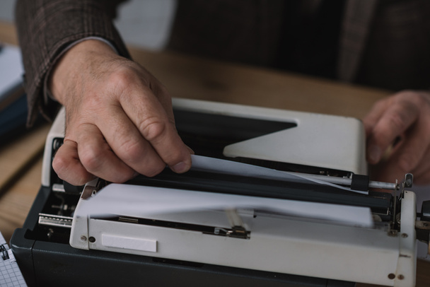 recortado disparo de la máquina de escribir papel de carga en la máquina de escribir
 - Foto, Imagen
