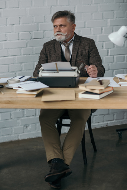 guapo escritor senior en traje de tweed trabajando con máquina de escribir
 - Foto, Imagen