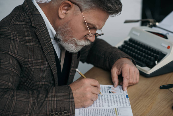 escritor senior con libro de lectura a lápiz en el lugar de trabajo
 - Foto, Imagen