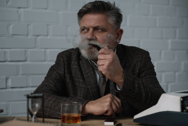 handsome senior writr smoking pipe at workplace - Valokuva, kuva