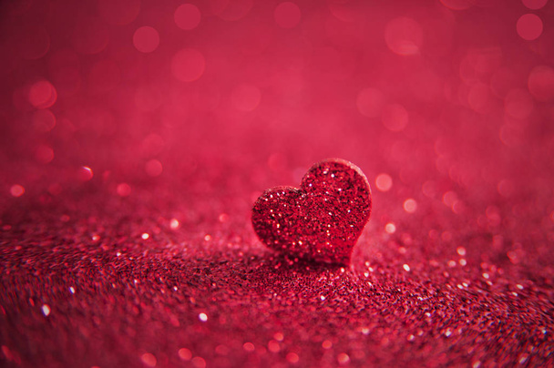 Valentines φωτεινό ροζ καρδιά σε ένα κόκκινο φόντο glitter. Καλλιτεχνική μακροφωτογραφία - Φωτογραφία, εικόνα