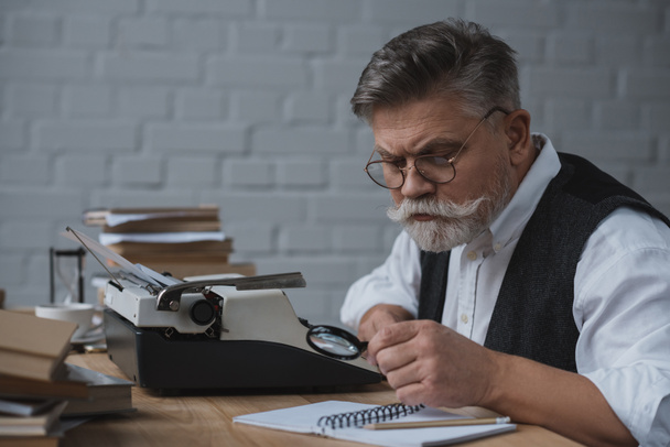 старший писатель переписывает рукопись с помощью печатной машины
 - Фото, изображение