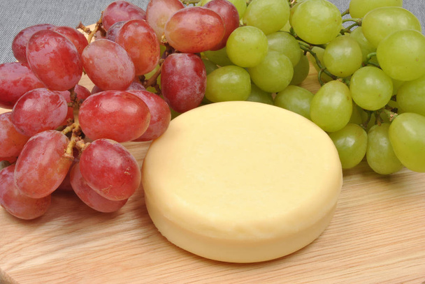 close-up of tasty Home Made Cheese With Grapes In The Background - Foto, immagini