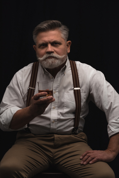 handsome senior man with glass of whiskey isolated on black - Foto, immagini