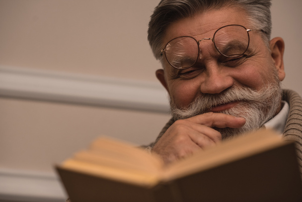 close-up portrait of senior man reading book - Фото, изображение