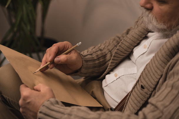close-up shot of bearded senior man writing letter - Foto, Bild