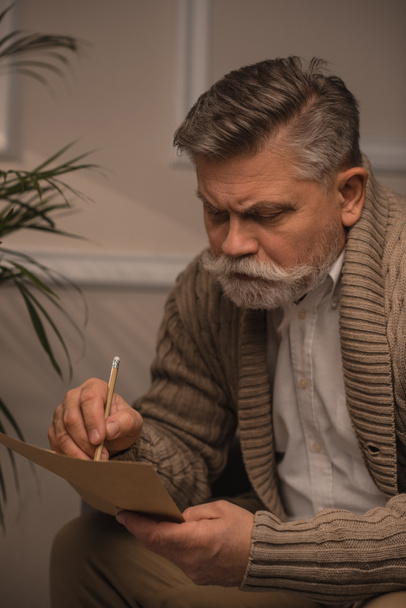 zamyšleně starší muž v svetru, psaní dopisu - Fotografie, Obrázek