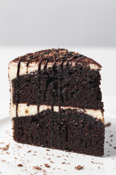 Closeup view of chocolate cake with glaze on white plate  - Photo, Image