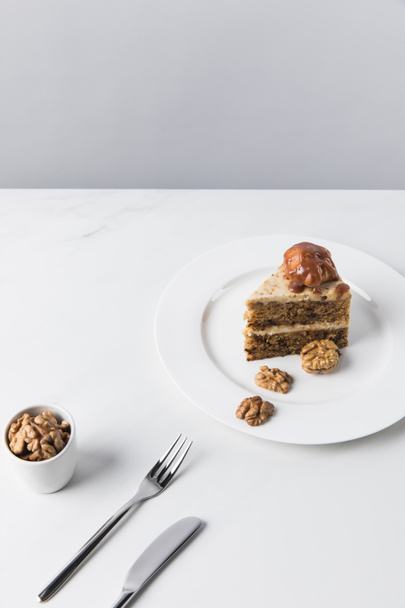 Ciasto na płycie z miski orzechów włoskich na biały stół - Zdjęcie, obraz